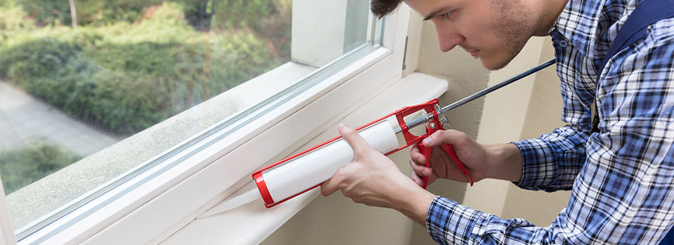 Close-up Of A Young Male Worker Applying Silicone Sealant With Silicone Gun