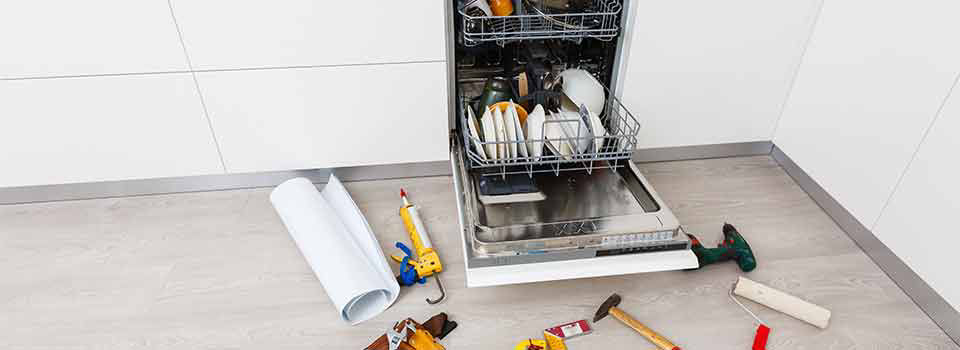 A broken dishwasher with lots of suds on the bottom but missing the bottom rack. The top rack is filled with dishes.