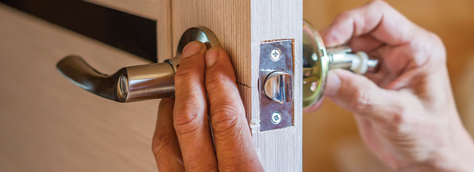 Person putting a new doorknock and lock on interior door