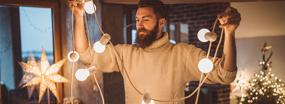 Man holding Christmas string lights