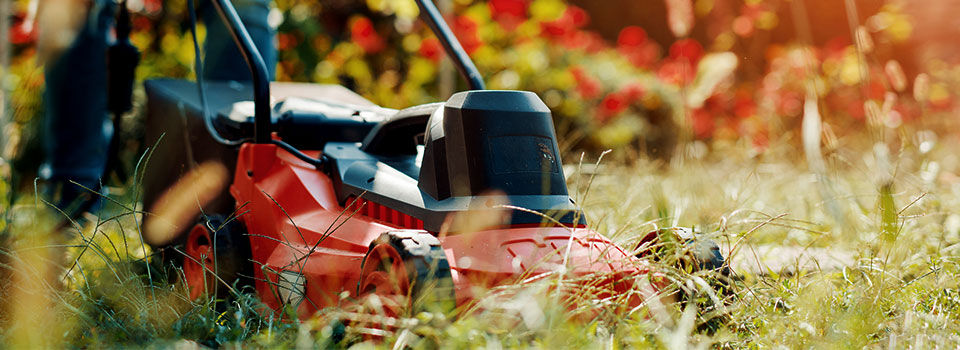 Close-up of someone mowing their yard with a red mower