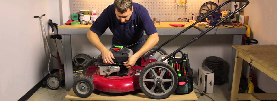 Man taking a look at a mower in his garage