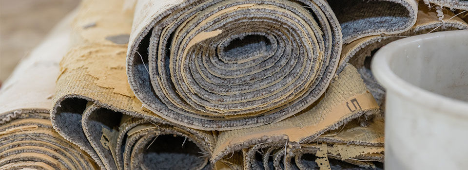 Rolls of old carpet stacked into a pile