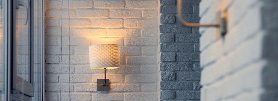 Wall sconce on white brick wall