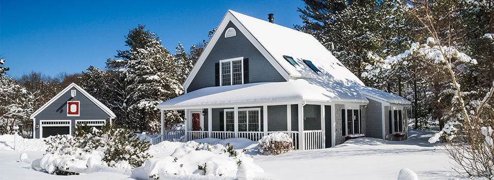 A small home and garage are covered with a fresh coating of snow during a Cape Cod Winter.