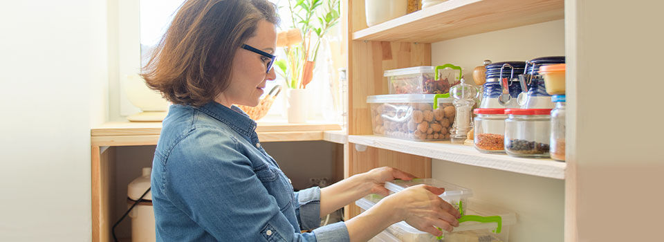 Woman placing storage containers on the shelf