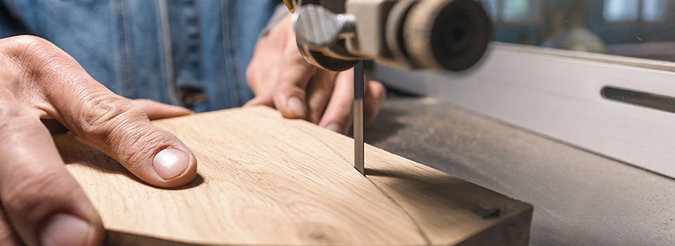 Young man carpenter builder working with electric jigsaw and wood