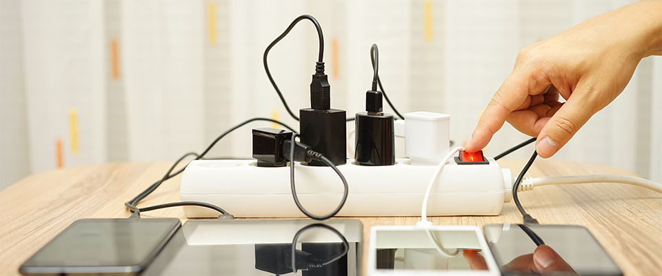 Person switching the power on an overloaded power strip