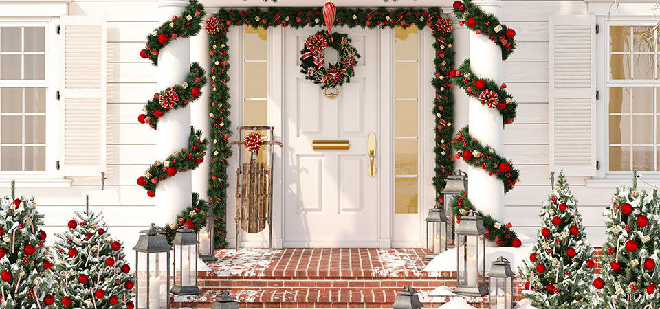 A house front porch and columns decorated for the winter season