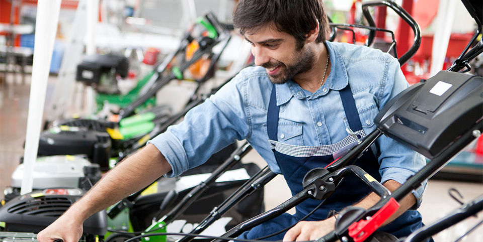 Store associate taking a look at a lawn mower
