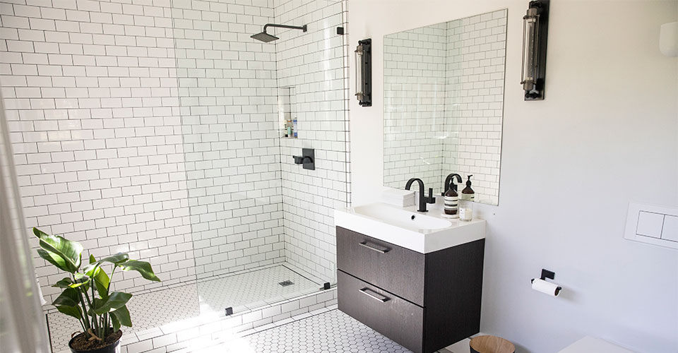 A white tiled bathroom floor and shower surround