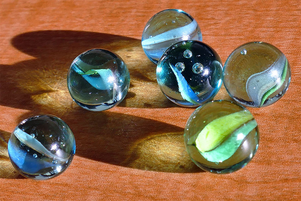 An assortment of colored marbles on a wooden table.