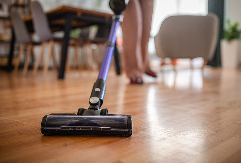 Someone vacuuming laminate flooring