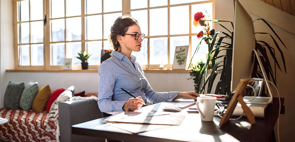 Woman wearing glasses working on her desktop in a home office