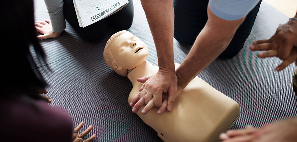 A group practicing chest compressions on a test dummy