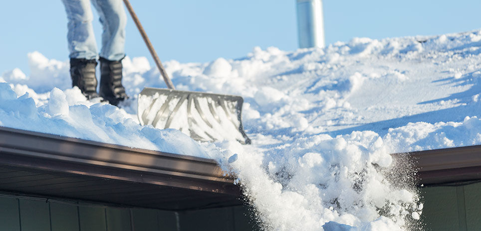 Person on their roof shoveling snow off