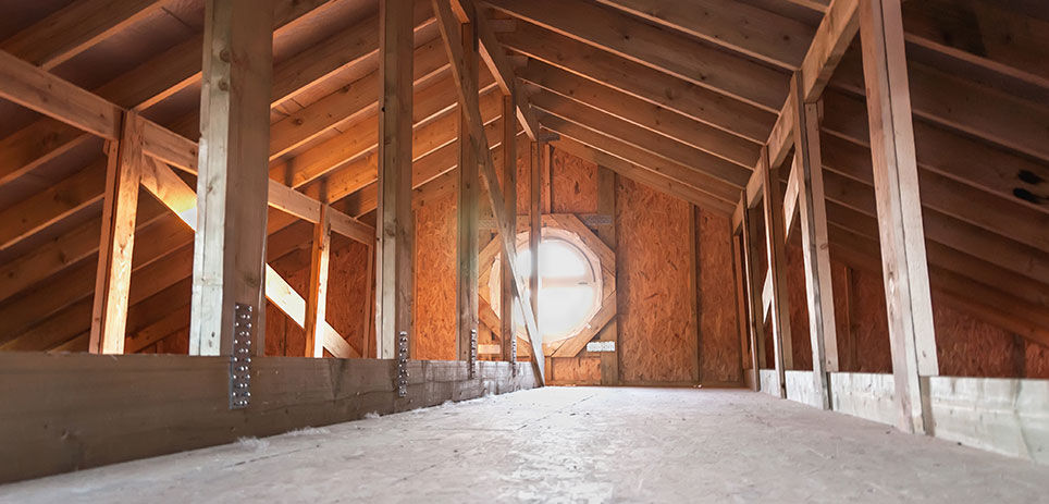 Showing the attic of a house with sunlight coming through the window