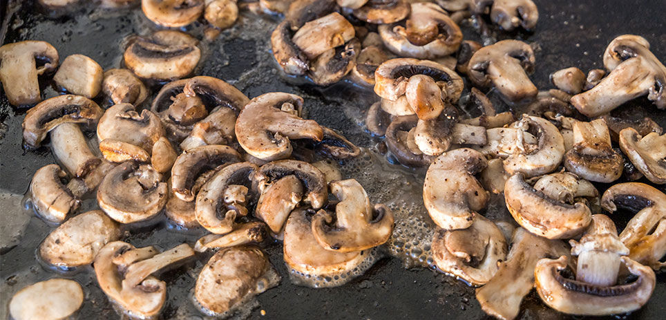 Mushrooms cooking on the griddle