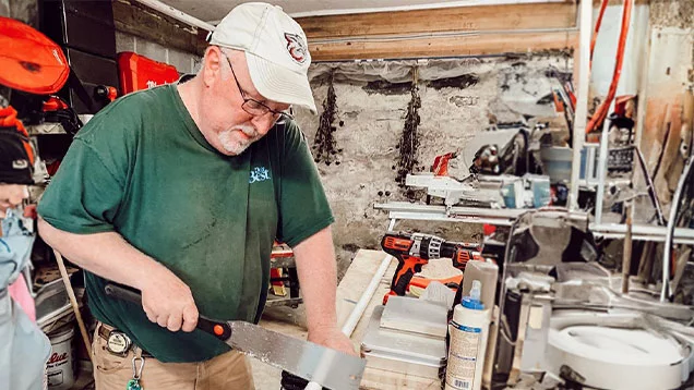 Employee Cutting The Pipe With Sharp Knife