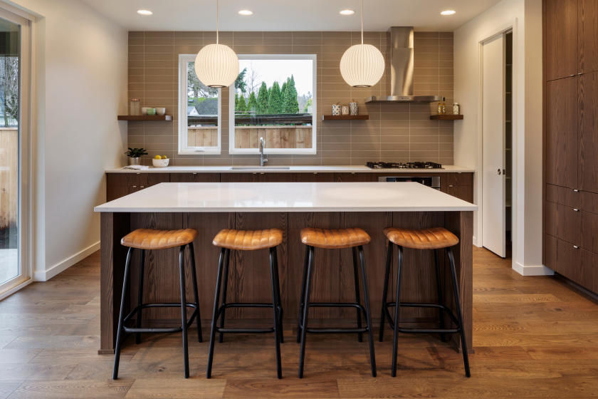 Modern kitchen island with round pendant lights and backless bar stools