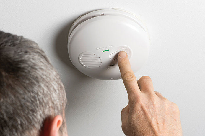 A man testing a smoke detector